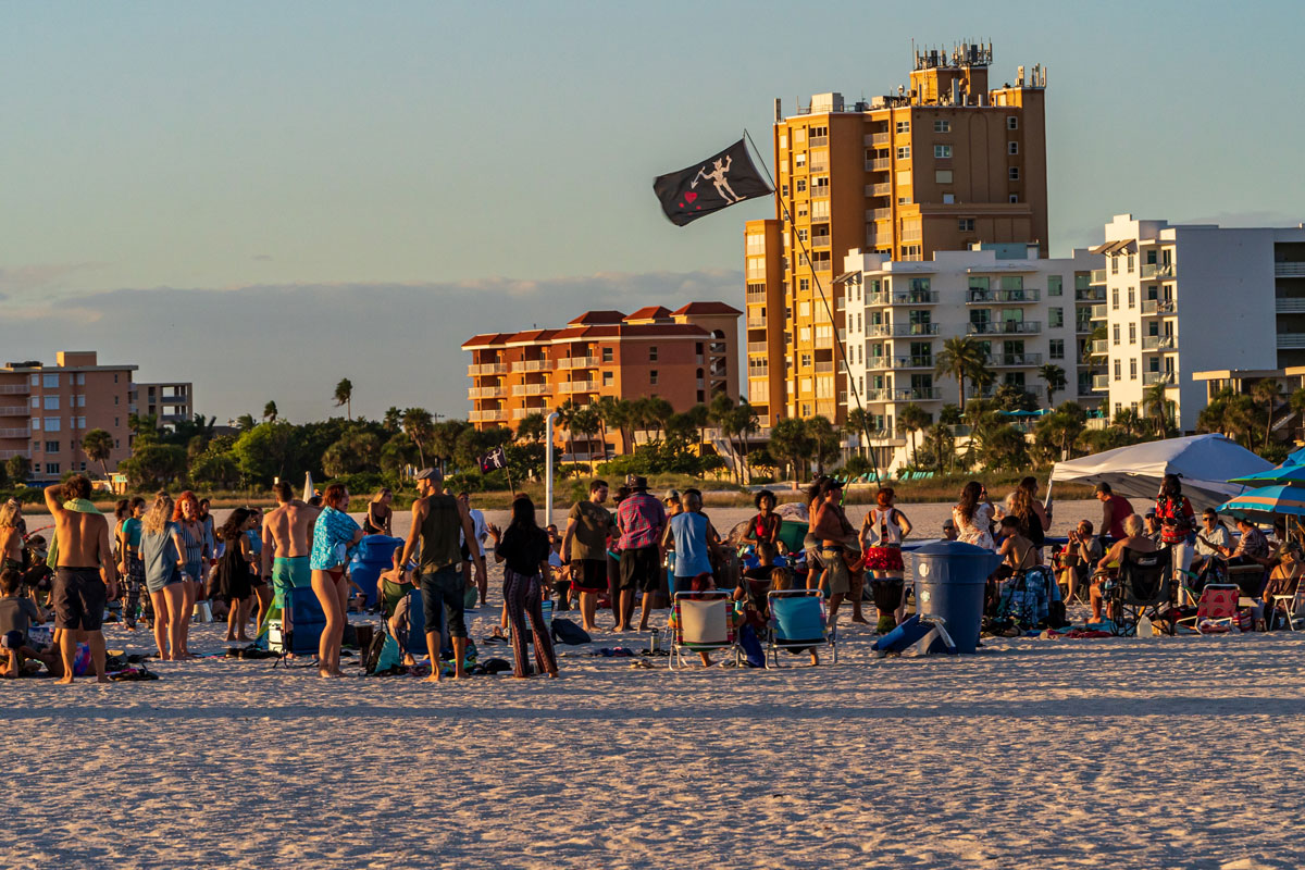 A group of people on a beach with buildings in the background